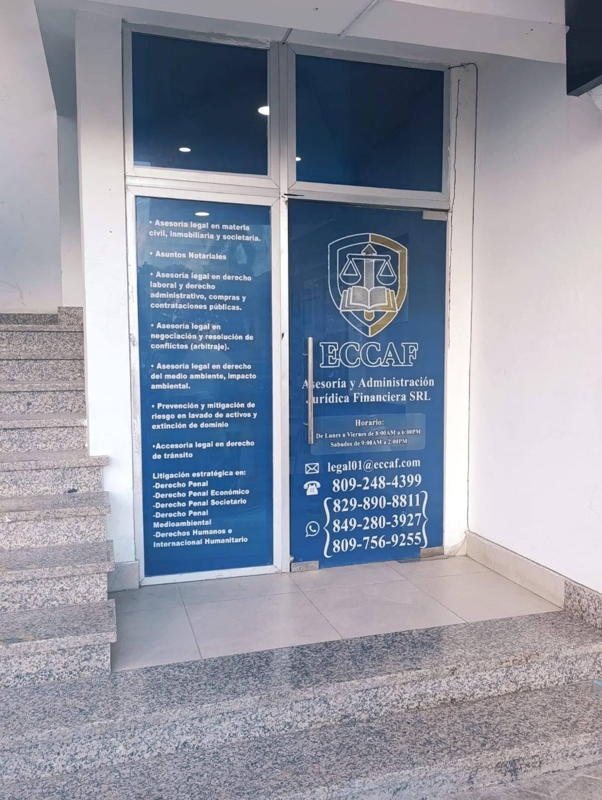 The entrance to the ECCAF office, showing business hours and contact information on the glass door.